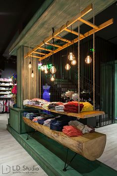 an open air clothing store with lots of clothes on display and lights hanging from the ceiling