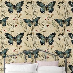 a bed sitting under a wallpaper covered in blue butterflies and berries on top of it