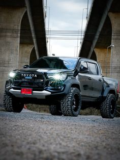 a toyota truck is parked under a bridge