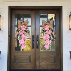 the front door is decorated with pink flowers and burlocked in brown bows