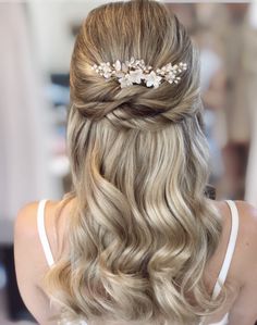 the back of a woman's head with blonde hair and flowers in her hair