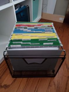 a stack of folders sitting on top of a wooden floor