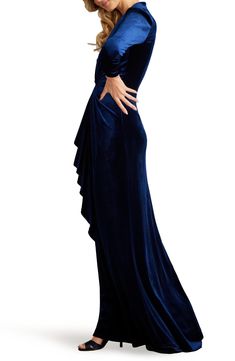 The timeless beauty of blue velvet is showcased here in a knotted gown designed with a dipped neckline. 60" length Hidden back-zip closure Deep V-neck Long sleeves 95% polyester, 5% spandex Dry clean Imported Velvet Evening Gown Floor-length, Floor-length Velvet Dress For Gala, Velvet Floor-length Evening Gown, Formal Velvet Floor-length Gown, Velvet Maxi Evening Dress For Gala, Elegant Blue Velvet Evening Dress, Elegant Blue Velvet Dress, Long Sleeve Velvet Gown, Drape Gown