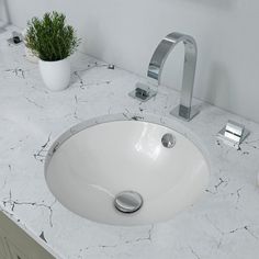 a white bathroom sink sitting under a faucet on top of a marble counter