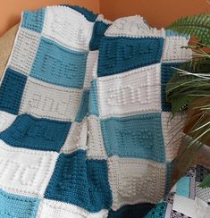 a crocheted blanket sitting next to a potted plant