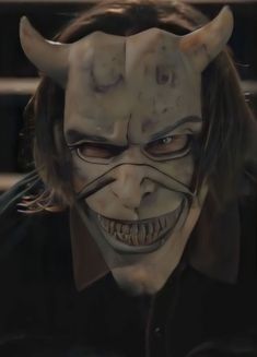 an evil looking man with horns on his head