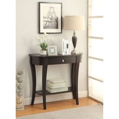 there is a small table with books and flowers on it next to a framed photograph