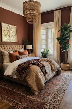 a bedroom with a bed, rug and chandelier hanging from the ceiling in front of two windows