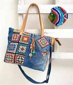 a handbag hanging on the side of a white wooden wall next to a multicolored fish