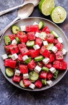 watermelon, cucumber and feta salad on a plate with spoons