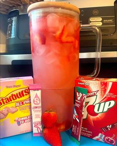 a drink with ice and strawberries next to some other items on a counter top