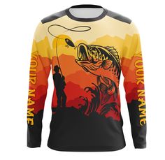 a long sleeved fishing shirt with an image of a man holding a fish on it