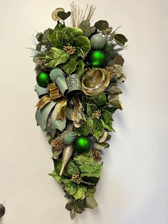 a green and gold christmas wreath hanging on the wall