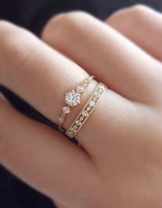 a woman's hand with two rings on her finger and one ring in the middle