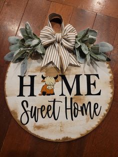 a wooden sign that says home sweet home with a bow on it's head