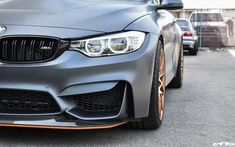 the front end of a silver car parked in a parking lot