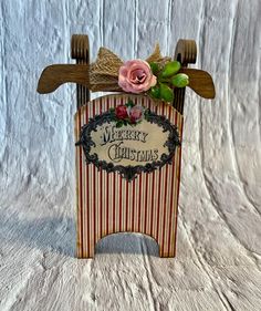 a christmas card holder with a pink rose on top