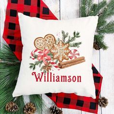 a personalized christmas pillow sitting on top of a red and black checkered blanket