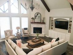 a living room filled with furniture and a flat screen tv mounted on the wall above a fireplace