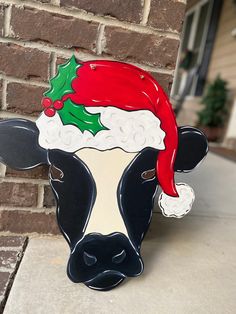 a black and white cow wearing a santa hat