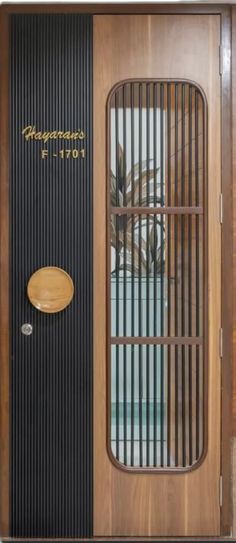 a wooden door with metal bars on the side and a round glass window above it