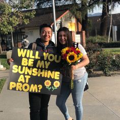 a man and woman holding a sign that says will you be my sunshine at prom?