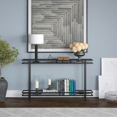 a living room with a book shelf and vases on the table next to it