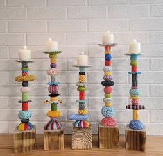 a group of candles sitting on top of wooden blocks with different colored beads around them