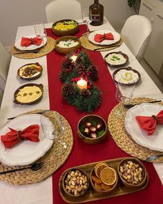 the table is set for christmas dinner with plates and silverware