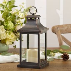 a candle is sitting on a table next to flowers