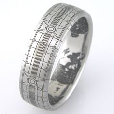 a wedding ring with black and white designs on it's side, against a white background