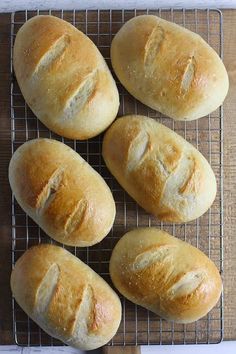 four loaves of bread sitting on a cooling rack