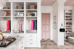 a walk in closet filled with lots of clothes and bags on top of white shelves