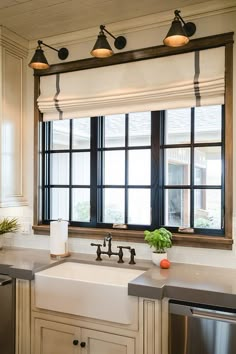 an image of a kitchen window with two lights above it and a sink in front of the window