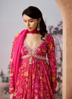 Step into refined elegance with this chintz-printed anarkali, beautifully adorned with dabka and French knot hand embroidery on the neckline. The ensemble is paired with a delicate silk organza dupatta, adding a touch of grace and sophistication, making it perfect for festive occasions or celebrations. Floral Chintz, Printed Anarkali, French Knot, Organza Dupatta, Embroidered Neckline, Silk Organza, Churidar, Fuchsia Pink, Indian Design