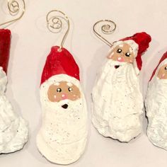 three santa clause ornaments hanging from hooks