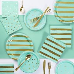 a table set with blue plates and gold striped napkins