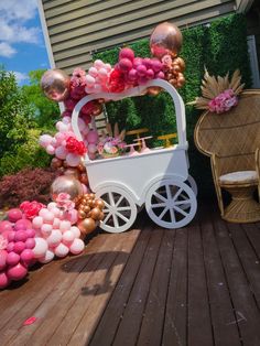 a white cart with balloons and flowers on it