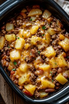 a casserole dish with potatoes and ground beef in it on a wooden table