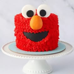 a red cake with eyes and nose on a plate