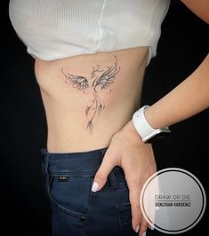 a woman's stomach with an angel tattoo on her belly and the bottom part of her abdomen