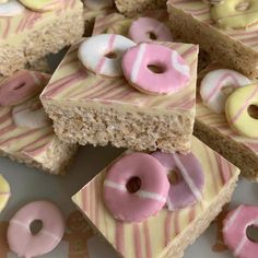 several pieces of cake with pink and white frosting on top, surrounded by doughnuts