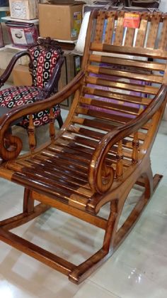 a wooden rocking chair sitting on top of a tile floor next to a box filled with boxes