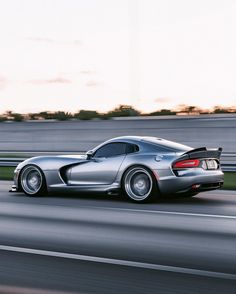 a silver sports car driving down the road