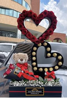 a teddy bear sitting in the back of a car with roses and hearts on it