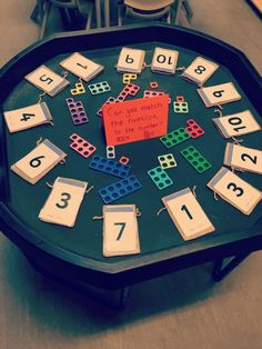 a black table with numbers and dices on it in the middle of a room