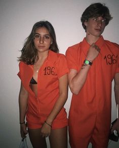 two people in orange prison uniforms standing next to each other with their hands on their hipss