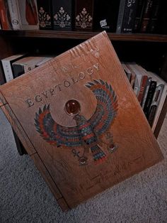 an old book is sitting on the floor in front of bookshelves and shelves