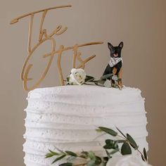 a white cake topped with a dog figurine and the words the gifts on top