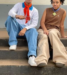 two young men sitting on steps with one holding a red frisbee